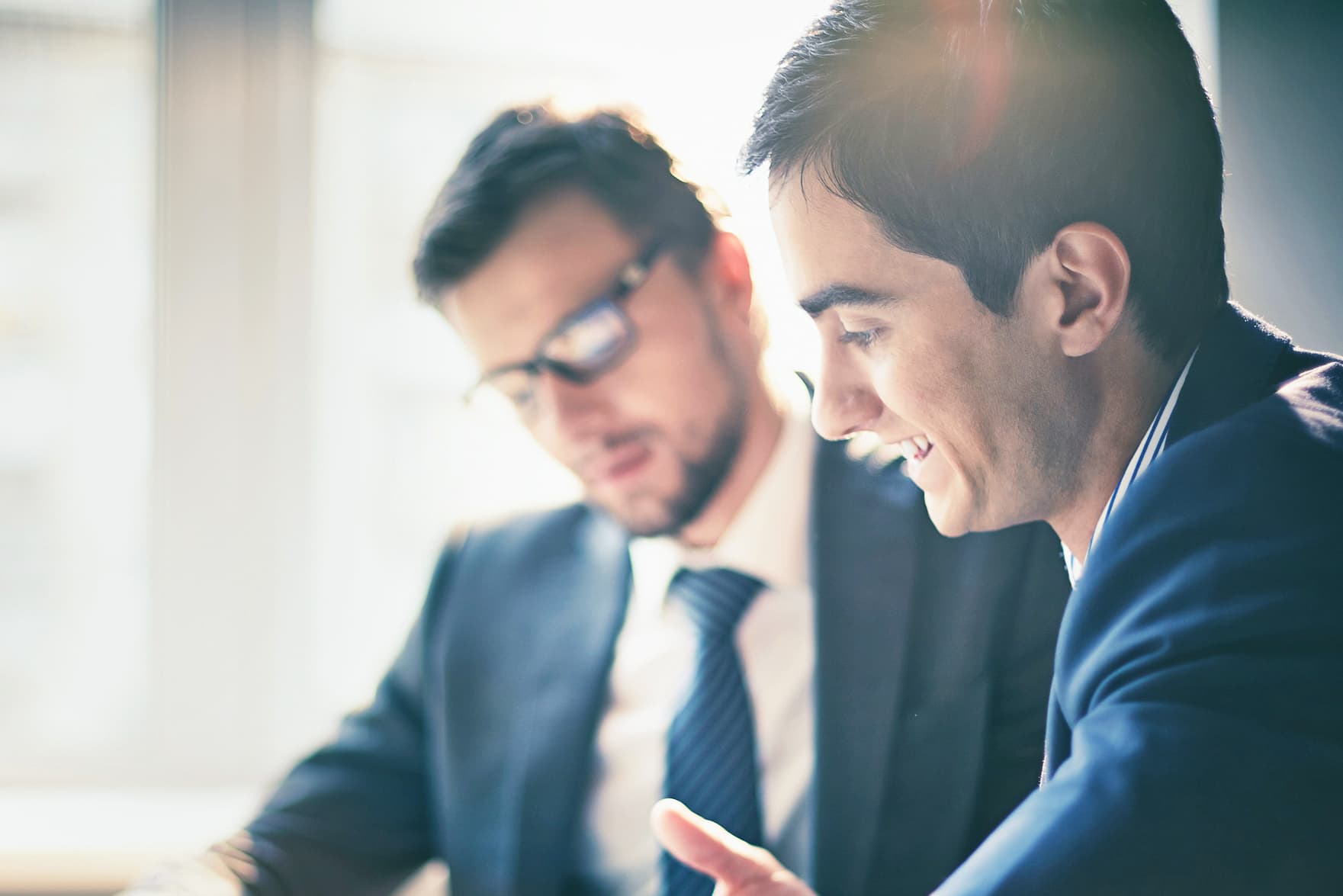 Zwei Personen besprechen Unterlagen in einem Meeting